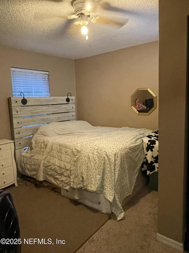 carpeted bedroom featuring ceiling fan and a textured ceiling