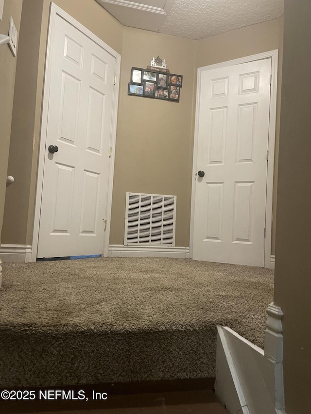 unfurnished bedroom featuring carpet floors and a textured ceiling