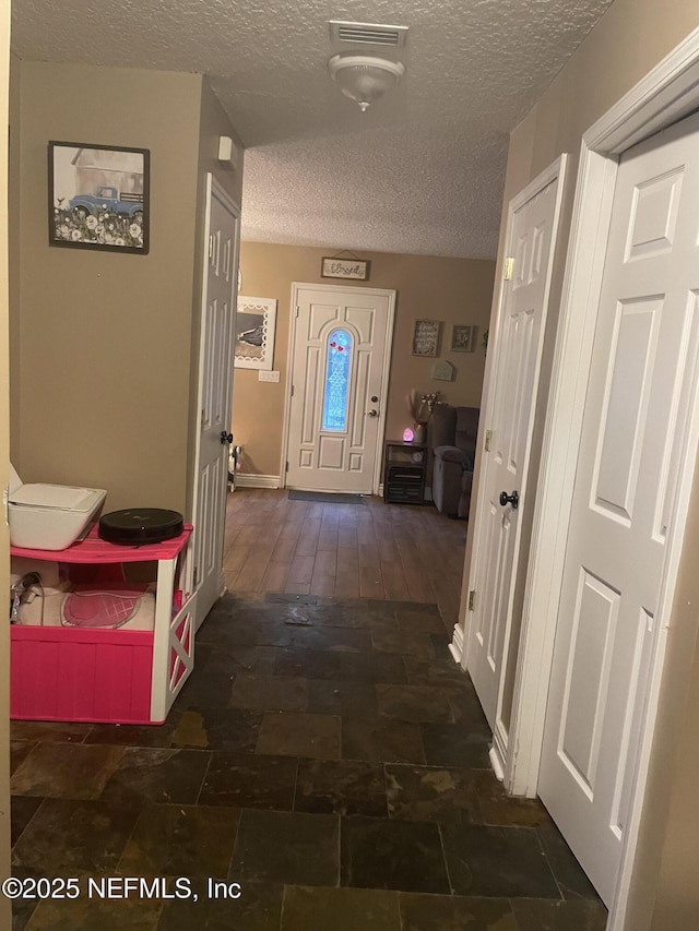 hall featuring a textured ceiling