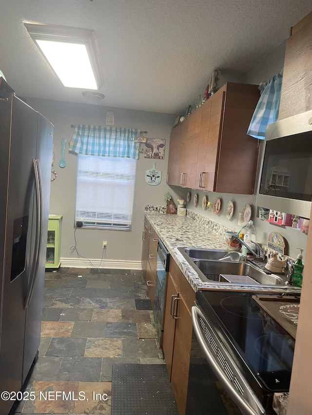 kitchen with stainless steel appliances, sink, and a textured ceiling