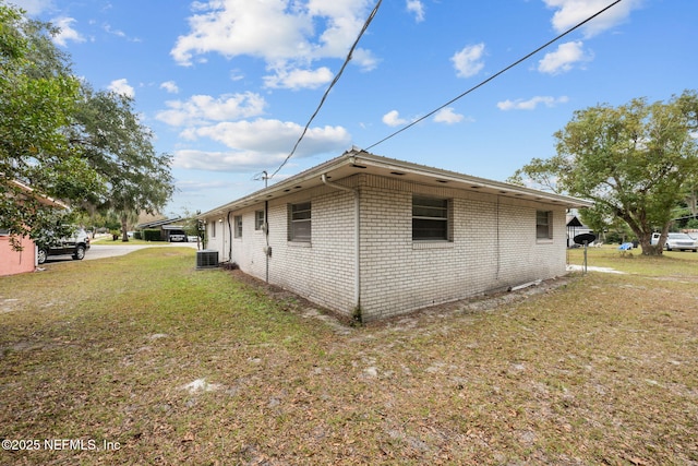 view of side of property featuring cooling unit and a lawn