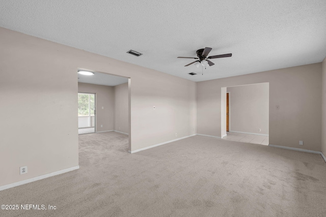 carpeted spare room with a textured ceiling and ceiling fan