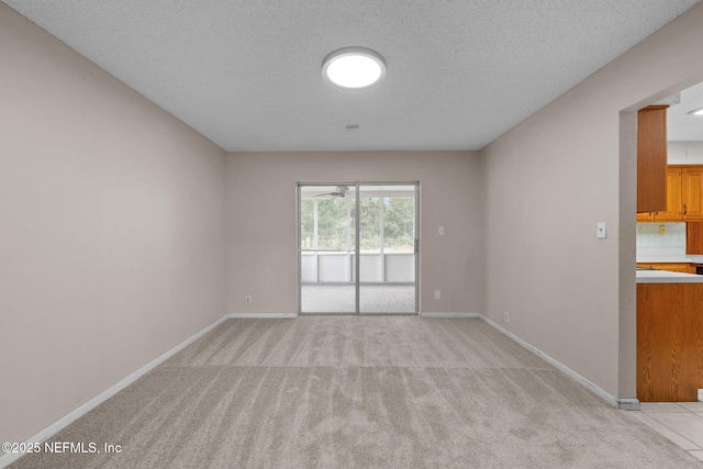 carpeted empty room featuring a textured ceiling