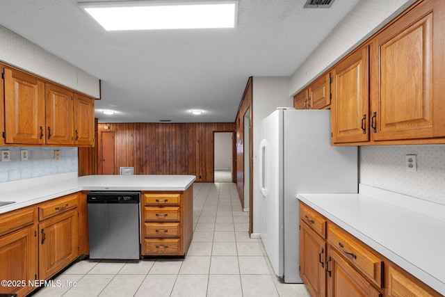 kitchen with refrigerator, stainless steel dishwasher, light tile patterned floors, kitchen peninsula, and a textured ceiling