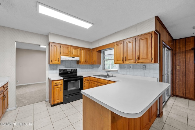 kitchen with sink, kitchen peninsula, black range with electric cooktop, and a textured ceiling