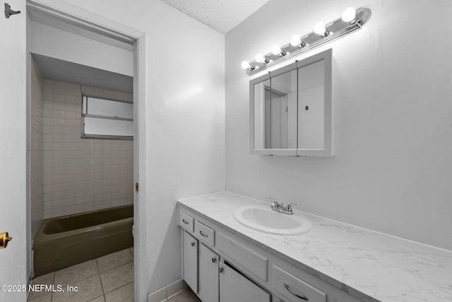 bathroom featuring tile patterned floors, tiled shower / bath combo, vanity, and a textured ceiling