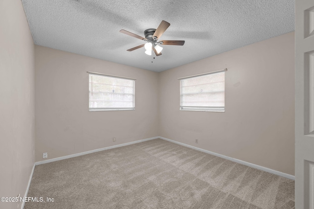 empty room with a textured ceiling, light colored carpet, and ceiling fan