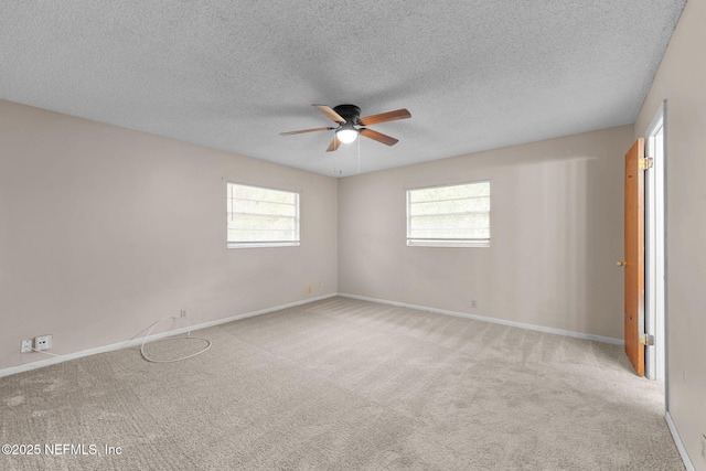 carpeted spare room featuring ceiling fan and a textured ceiling