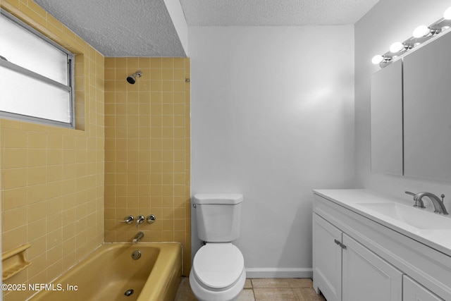 full bathroom with vanity, tiled shower / bath combo, a textured ceiling, and toilet