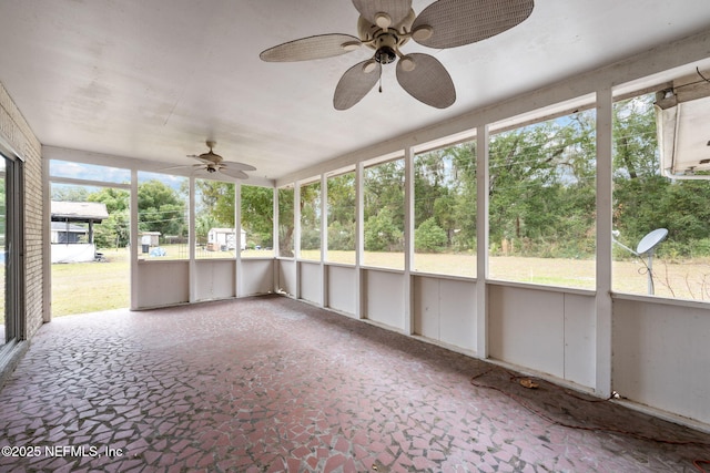 unfurnished sunroom with ceiling fan and a healthy amount of sunlight