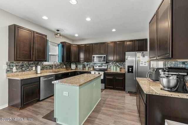 kitchen featuring appliances with stainless steel finishes, a center island, sink, and decorative backsplash