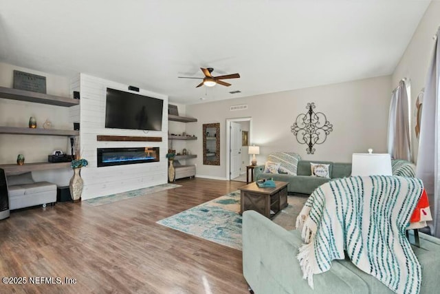 living room featuring ceiling fan and dark hardwood / wood-style floors