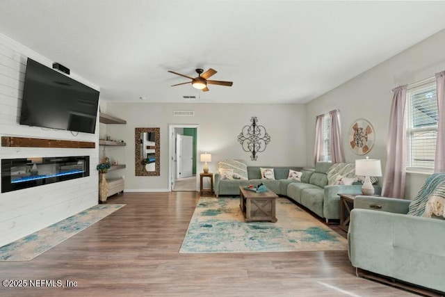 living room featuring wood-type flooring and ceiling fan