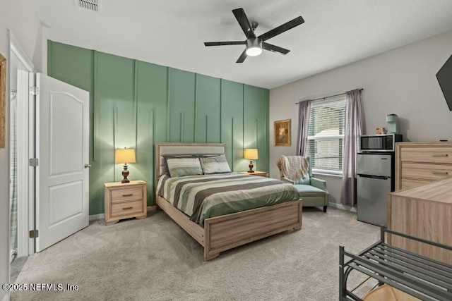 bedroom with light carpet, stainless steel fridge, and ceiling fan