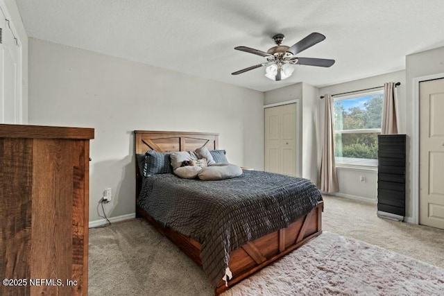 carpeted bedroom featuring two closets and ceiling fan