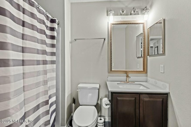 bathroom with vanity, toilet, and walk in shower