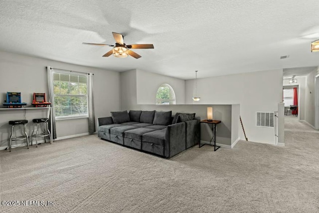 living room with a healthy amount of sunlight, light colored carpet, and a textured ceiling