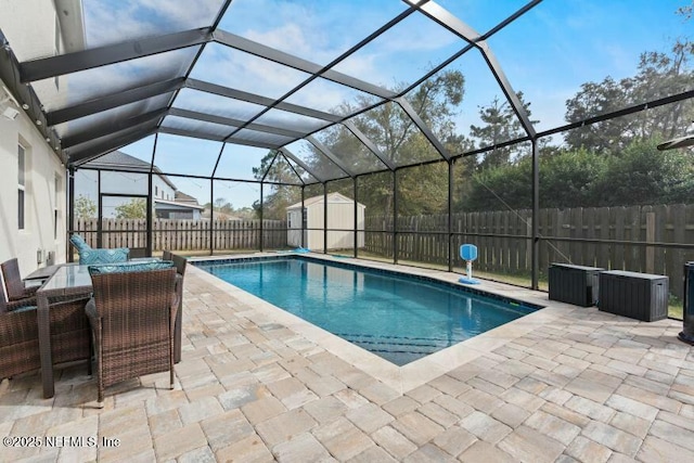 view of swimming pool featuring a patio area, a storage unit, and glass enclosure