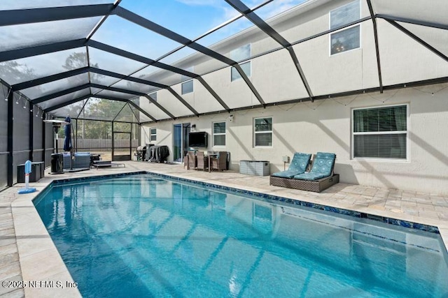 view of pool with a patio, an outdoor hangout area, and glass enclosure