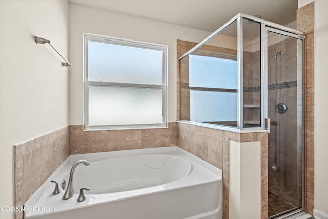 bathroom with separate shower and tub and a textured ceiling