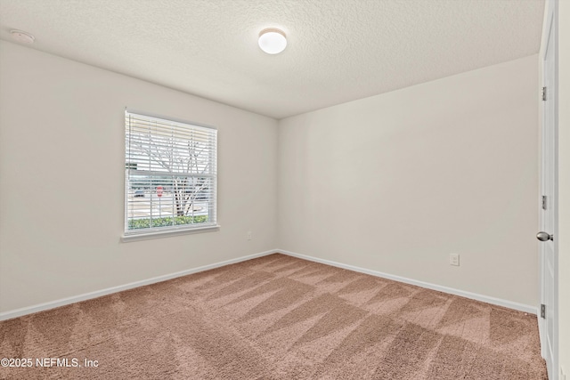 carpeted empty room featuring a textured ceiling