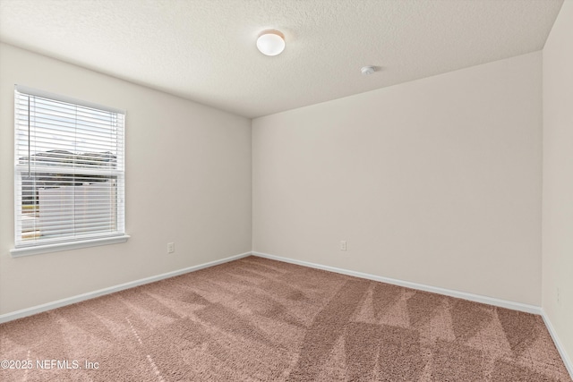 carpeted empty room with a textured ceiling