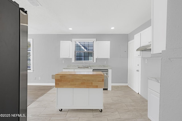 kitchen with a kitchen island, butcher block countertops, white cabinetry, dishwasher, and sink