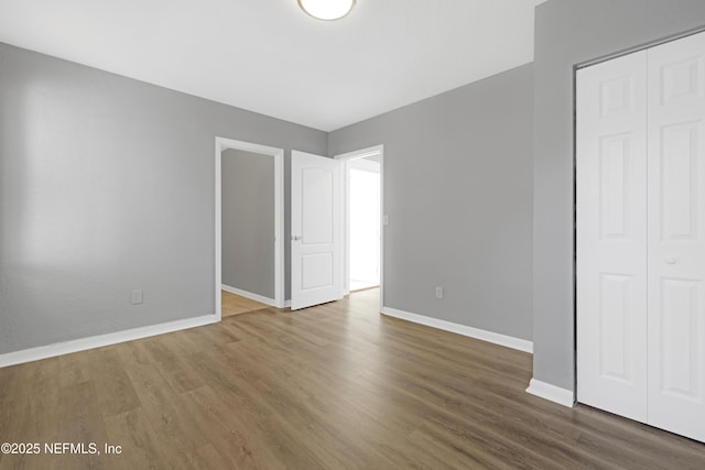 unfurnished bedroom featuring dark hardwood / wood-style flooring and a closet