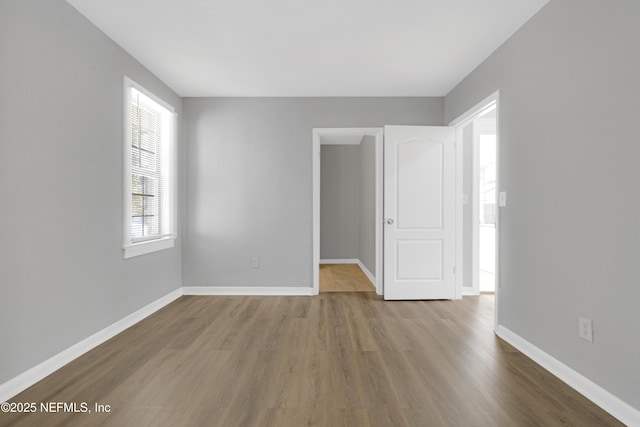 unfurnished room with wood-type flooring