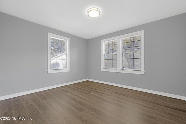 unfurnished room featuring dark hardwood / wood-style flooring and a wealth of natural light