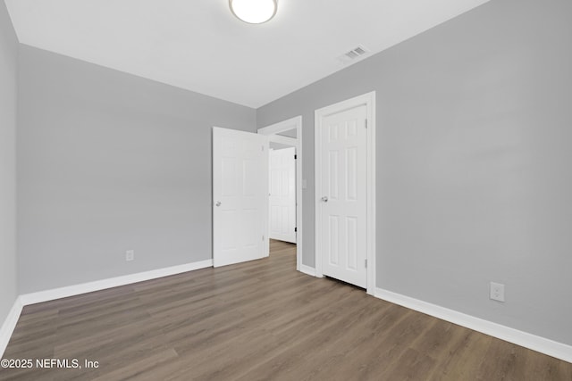 unfurnished bedroom with dark hardwood / wood-style flooring