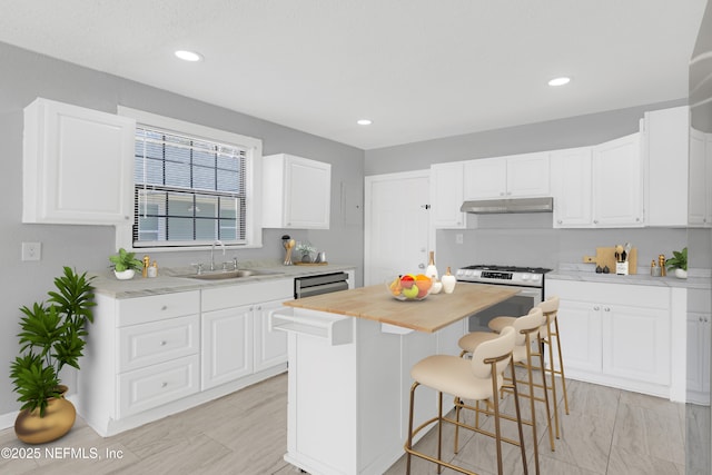 kitchen featuring white cabinetry, a breakfast bar, a center island, and sink