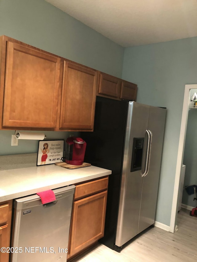 kitchen with stainless steel appliances and light hardwood / wood-style floors