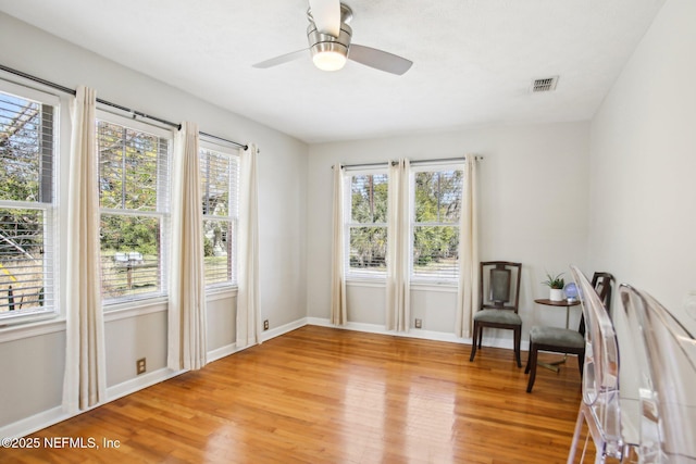 sitting room with hardwood / wood-style floors and ceiling fan