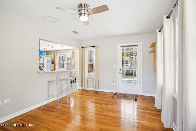 foyer entrance featuring wood-type flooring, a healthy amount of sunlight, and ceiling fan