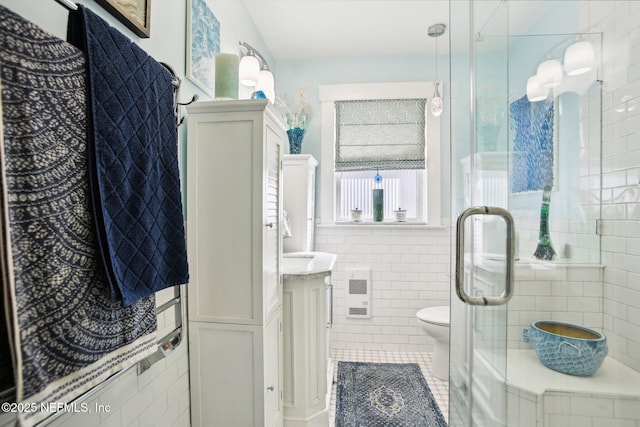 bathroom with toilet, heating unit, tile walls, vanity, and tile patterned flooring