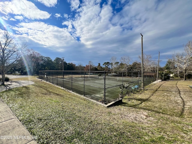 view of tennis court with a lawn