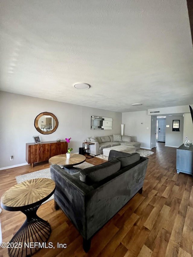 living room featuring dark hardwood / wood-style flooring and a textured ceiling