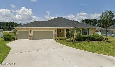 ranch-style house featuring a garage and a front yard