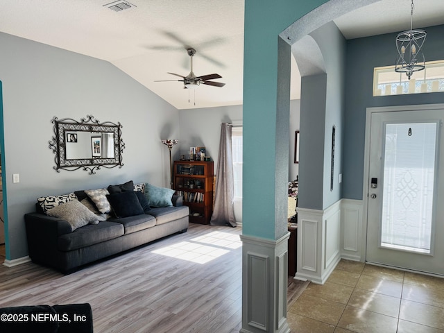 tiled living room with lofted ceiling and ceiling fan