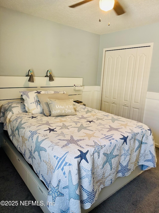 carpeted bedroom with a textured ceiling, a closet, and ceiling fan