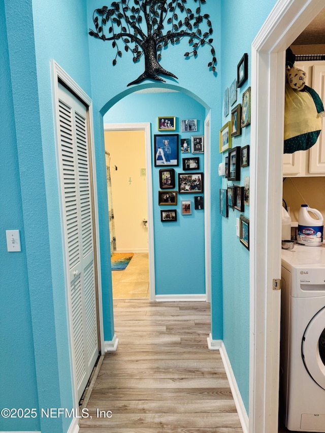 hall featuring washer / clothes dryer and light hardwood / wood-style flooring