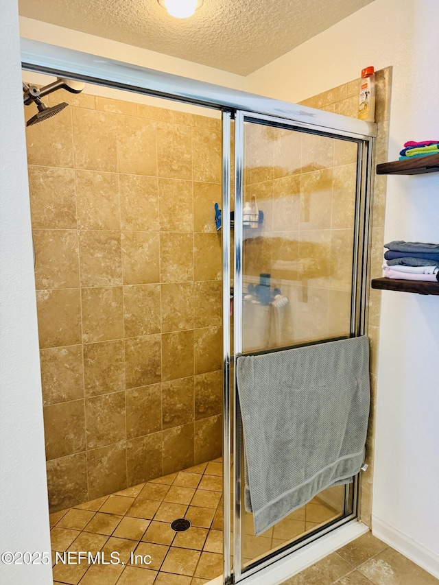 bathroom with a shower with door and a textured ceiling