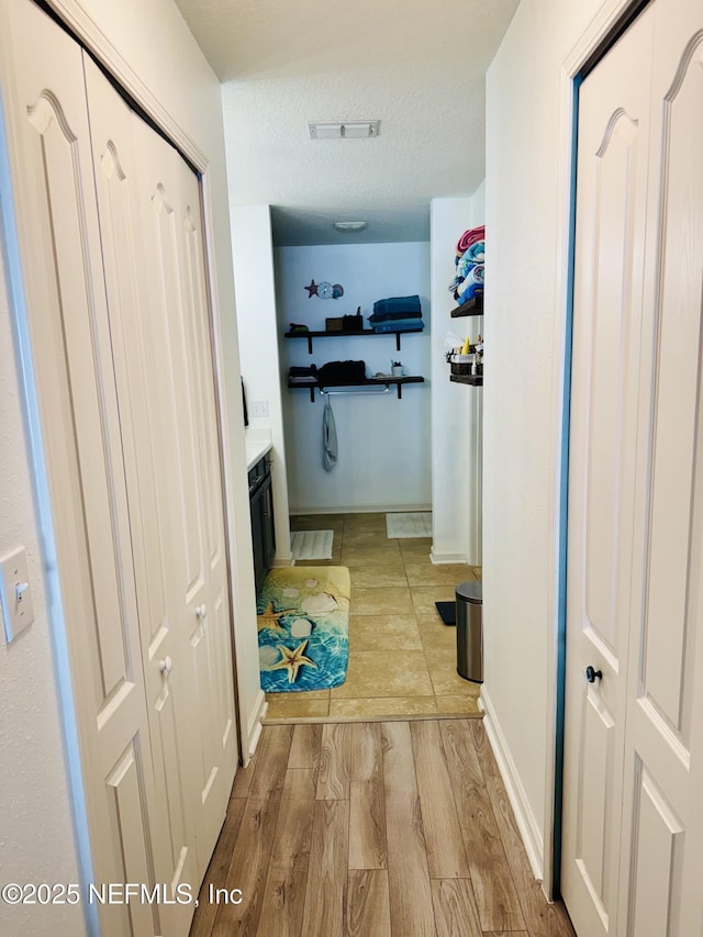 hallway with a textured ceiling