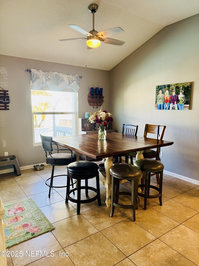 tiled dining space featuring vaulted ceiling and ceiling fan