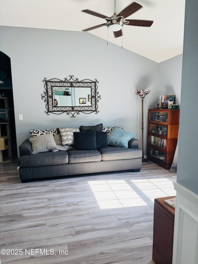 living room featuring ceiling fan, lofted ceiling, and light hardwood / wood-style floors