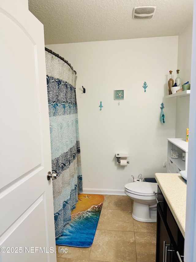 bathroom with vanity, tile patterned floors, toilet, and a textured ceiling