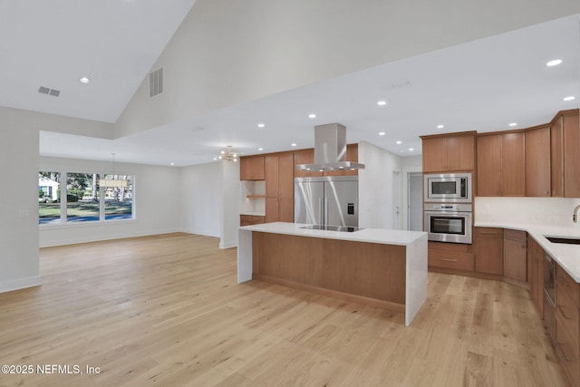 kitchen featuring a center island, built in appliances, a notable chandelier, light hardwood / wood-style floors, and island exhaust hood