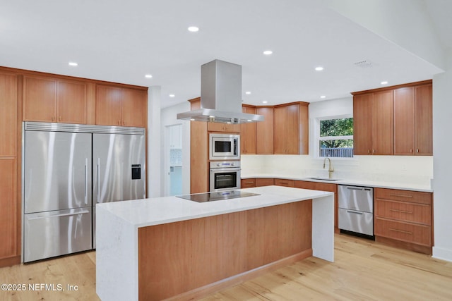 kitchen featuring island range hood, sink, a center island, built in appliances, and light hardwood / wood-style flooring