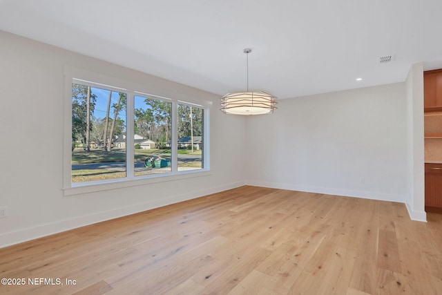 unfurnished dining area featuring light wood-type flooring